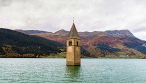 Graun, 2019. október 28.
A Graun nevû település templomának tornya a Reschensee, olaszul Lago di Resia nevû mesterséges tóban, Dél-Tirolban 2019. október 28-án. A helyi tiltakozás ellenére a három kisebb tó, a Reschensee, a Mittersee és a Haidersee összevonásából keletkezett víztározó 1950 júliusára megépült. Összesen 163 otthon és 523 hektárnyi termõföld került a víz alá, a településbõl egyedül a templom tornya maradt meg épségben történelmi emlékként.
MTI/EPA/Christian Bruna